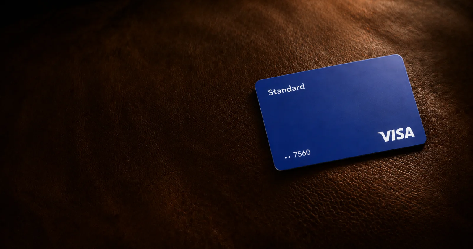 An indigo Dara card resting on warm cognac leather.